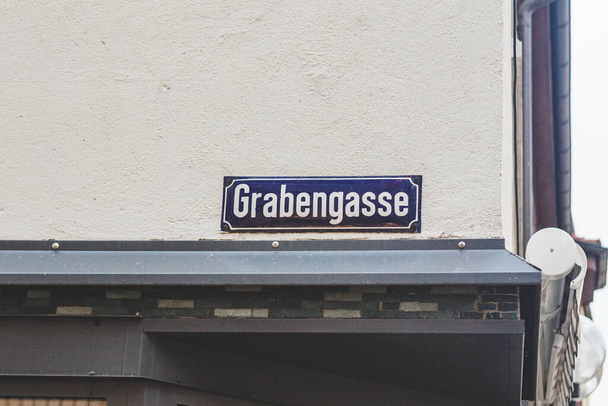 Assinatura do nome Grabengasse em Bad Kissingen, Alemanha. Um sinal de nome de rua é um sinal usado para identificar estradas nomeadas, geralmente aquelas que não se qualificam como vias expressas ou rodovias. - Foto, Imagem