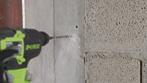 Man drilling hole in concrete wall. Repair works indoors in slow motion - Footage, Video