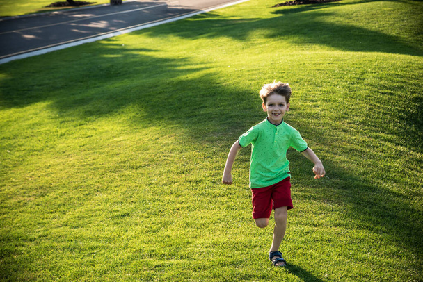 Little boy running on the grass on huge golf field. - Foto, immagini