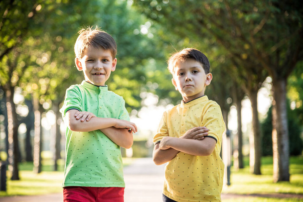 Deux enfants dans le parc, faisant drôle visage entouré de couleurs chaudes et ensoleillées. Concept d'amitié entre frères, famille heureuse. - Photo, image