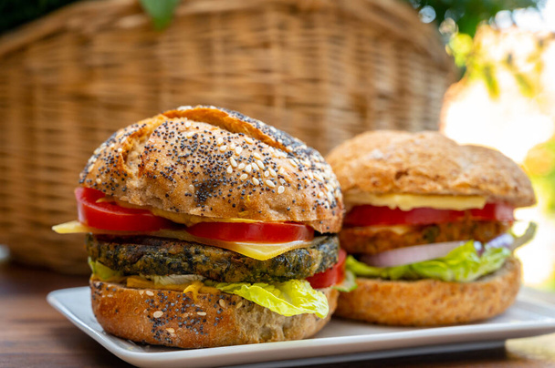 Jedzenie świeżych i zdrowych hamburgerów wegetariańskich z grillowanym szpinakiem lub hamburgerami z dyni, organiczne bułki i warzywa zbliżyć - Zdjęcie, obraz