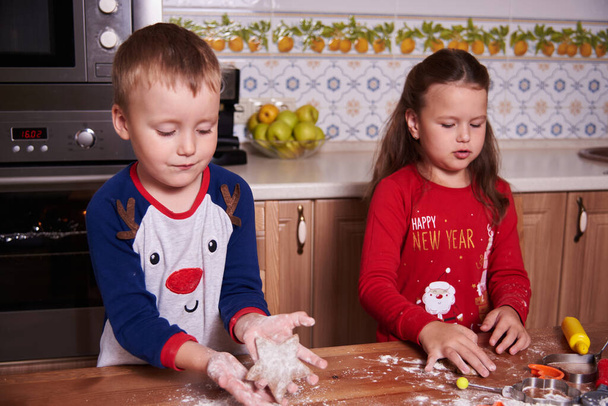 brother and sister prepare homemade cookies in the kitchen. The mood of the occasion. Fun and laughter - Fotografie, Obrázek