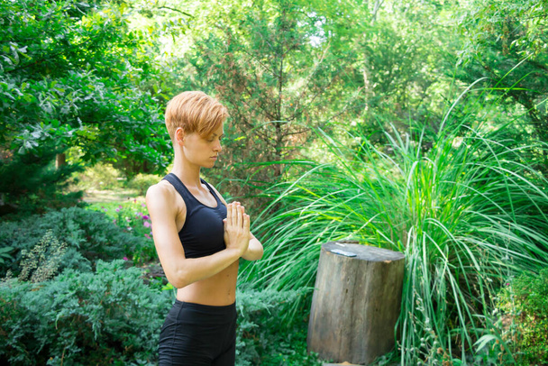 femme faisant du yoga dans le parc, jeune fille faisant divers exercices de bien-être, le concept d'un mode de vie sain et des soins de santé et son corps - Photo, image