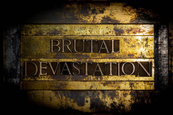 Brutal Devastation text message authentic on textured grunge copper and vintage gold background - Photo, Image