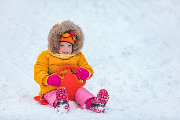 niño pequeño en el trineo deslizándose por la colina nevada de invierno - Foto, imagen