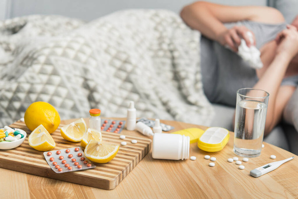 Молода жінка хворий на застуду та грип, самолікування вдома з вітамінами та таблетками. страждає від алергії
. - Фото, зображення