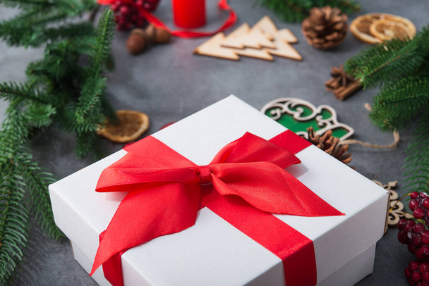 Neujahrskonzept mit Weihnachtsbaum und Holzspielzeug, roter Geschenkbox auf Steinhintergrund. - Foto, Bild
