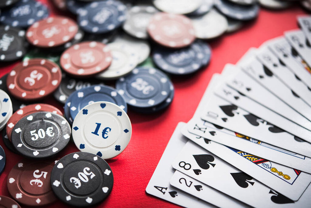 Ein Kartenspiel zum Pokern auf einem roten Tisch in einem Casino - Foto, Bild