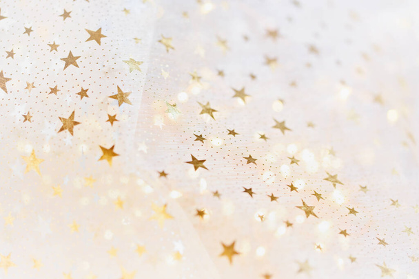 gold glitter and glittering stars on white festive background. Winter holidays background. Christmas and Happy New Year greeting card. Wedding. Birthday. selective focus - Fotografie, Obrázek