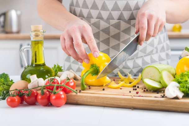 Zbliżenie kobiecych rąk krojących warzywa w kuchennym stole. Przepisy na prawidłowe odżywianie. Zdrowe odżywianie. Składniki na ciasto warzywne. - Zdjęcie, obraz