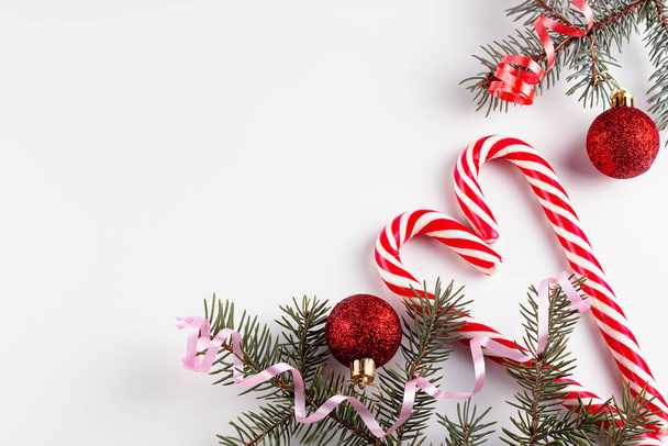 branches de sapin, décorations rouges sur fond blanc. Composition de Noël. Noël, hiver, nouvelle année concept. Pose plate, vue du dessus, espace de copie - Photo, image