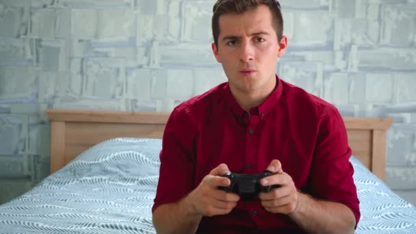 man sits on the couch and plays a video game console - Footage, Video