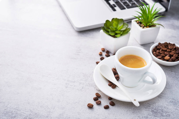 Espresso-Kaffee mit Laptop und grünen Pflanzen im Hintergrund. Kopierraum - Foto, Bild