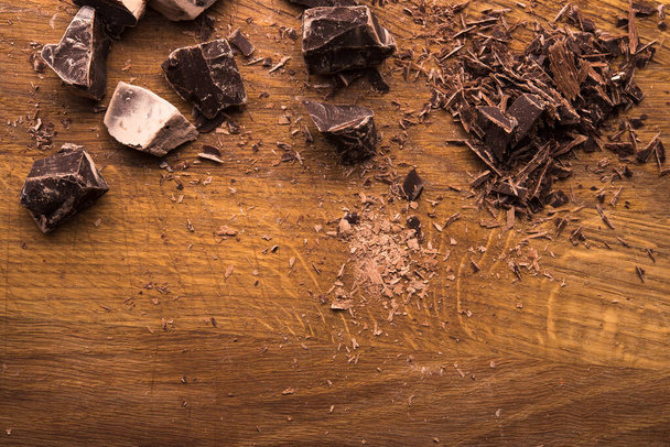 Cracked dark chocolate on a wooden background. copyspace. top view - Photo, Image