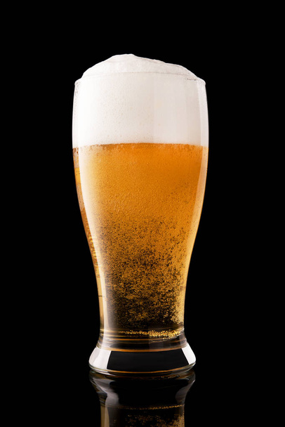 Glass of fresh beer isolated on a black background - Photo, Image