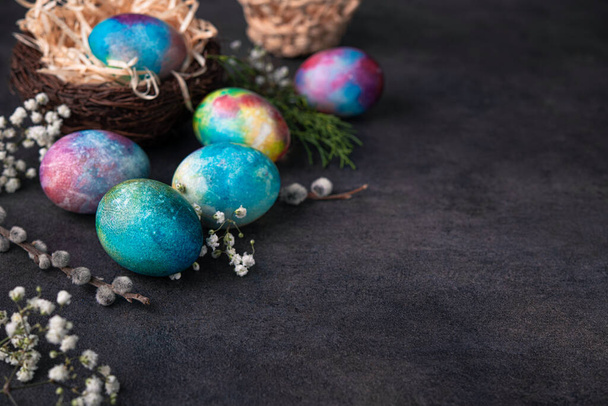 Conceito de férias de Páscoa com ovo de espaço colorido em um fundo de pedra escura. Espaço de cópia - Foto, Imagem