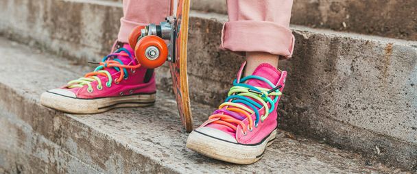 Close-up of female legs with pink sneakers and skate board. Banner, wide format - Photo, image