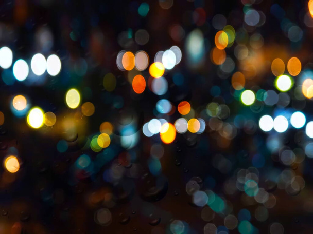 neon noite cidade embaçado luz e chuva gotas na janela de vidro estação chuvosa - Foto, Imagem
