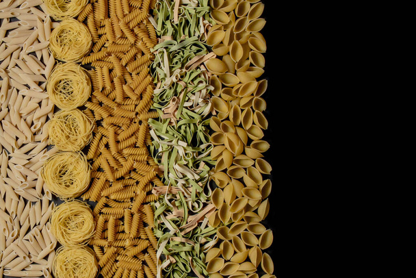 Variety of types and shapes of dry Italian pasta. Italian Macaroni raw food background or texture:pasta, spaghetti , pasta in shape of spiral - Fotografie, Obrázek