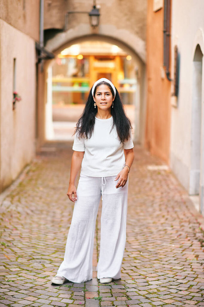 Beautiful middle age woman posing outside, wearing white clothes - Foto, imagen