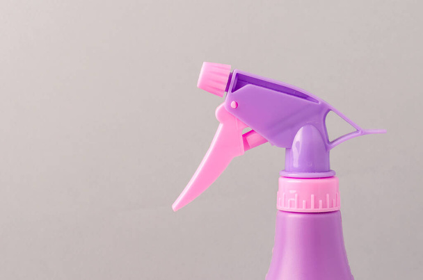 spray nozzle on a bottle/purple spray nozzle on a bottle on a grey background. Copy space. - Zdjęcie, obraz