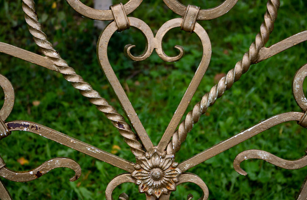 Elementos forjados en un banco de jardín en la forma de un corazón. muebles de hierro forjado de jardín en el jardín. - Foto, Imagen