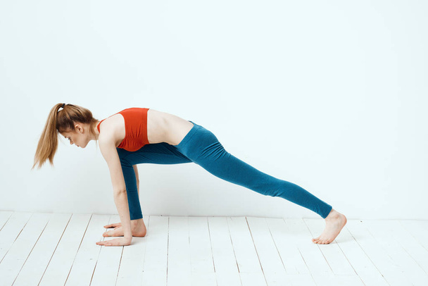 atlético mulher em pose no chão exercício ginástica desempenho luz fundo - Foto, Imagem