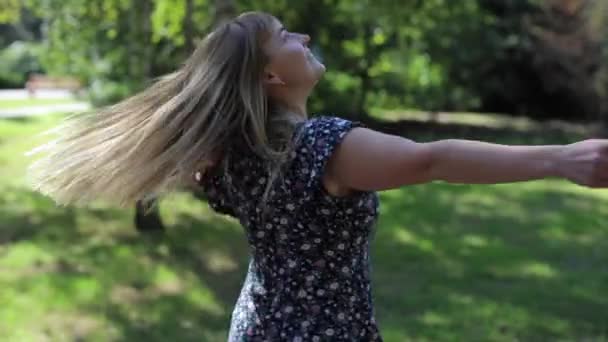 Gelukkig vrouw wervelend buiten in het park - Video