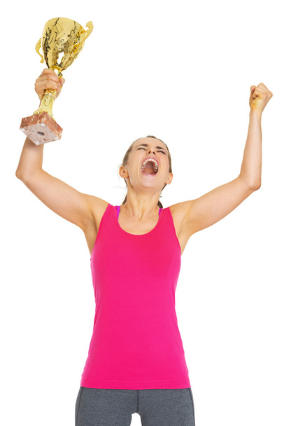 Happy fitness young woman with gold trophy cup rejoicing - 写真・画像