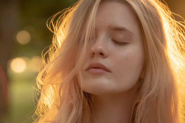 Outdoor fashion portrait of a  young woman with with straight blond hair at sunset - Fotoğraf, Görsel