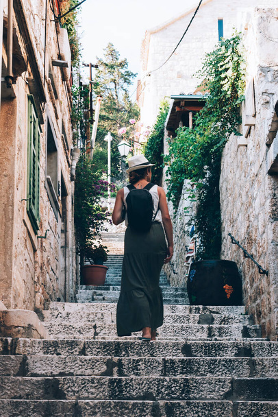 Woman tourist going up the steps of a narrow street, Hvar island, Croatia. - Foto, immagini