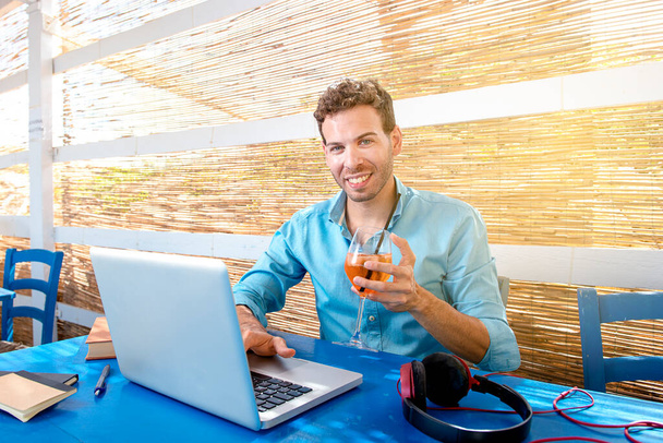 personas, ocio y tecnología concepto hombre con tablet PC beber cóctel en el bar de verano - Foto, imagen