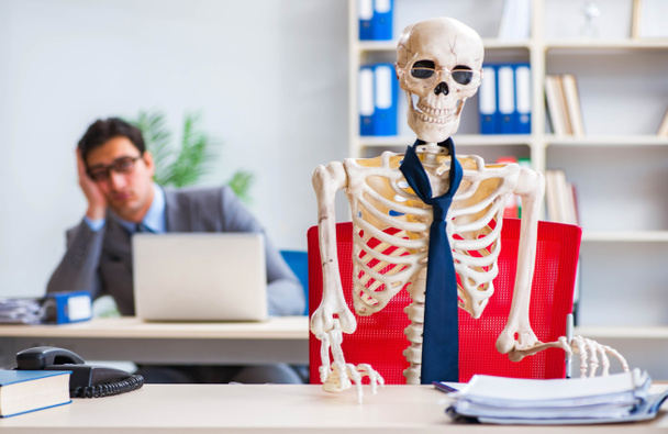 Biznesmen pracujący ze szkieletem w biurze - Zdjęcie, obraz