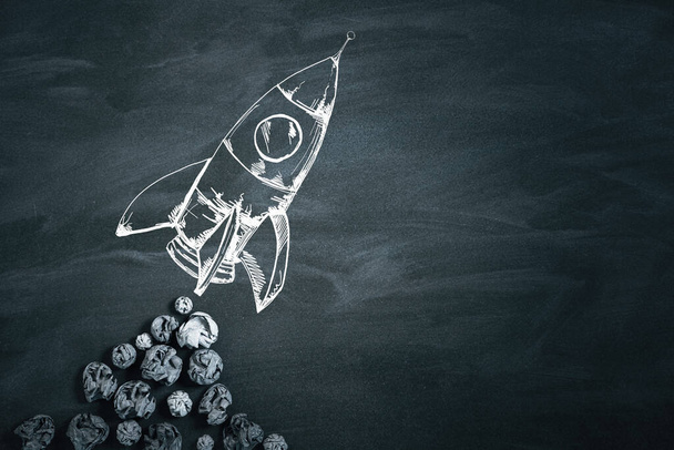 Crumpled papers and drawn rocket on blackboard. Success and startup concept. 3D Rendering - Фото, изображение