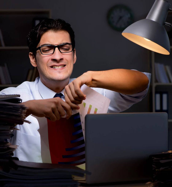 Молодий бізнесмен працює понаднормово пізно в офісі
 - Фото, зображення