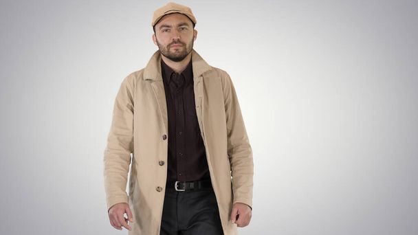 Fashionable man with dark beard in trench coat walking on gradie - Φωτογραφία, εικόνα