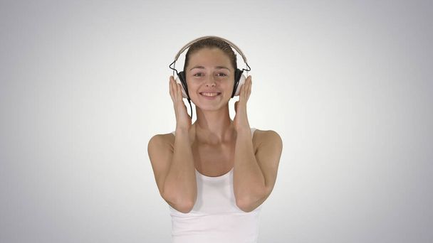 Woman with headphones listening music and making funny face on g - Foto, Bild