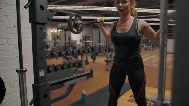 Sexy atleet vrouw doet lange halter hurken in slow motion - Video