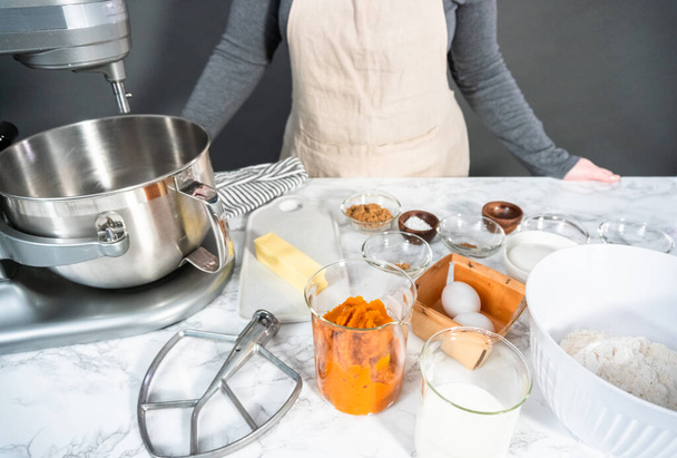 Ingredients to bake pumpkin spice cupcake on a marble countertop. - Photo, Image