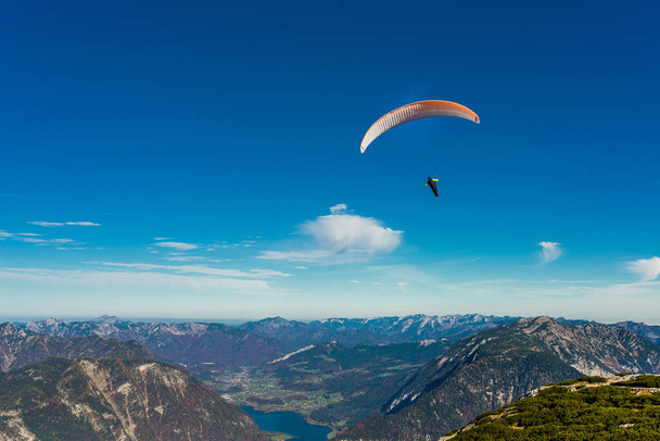 Paraglider vliegen in de blauwe lucht over de bergen van de Alpen - Foto, afbeelding