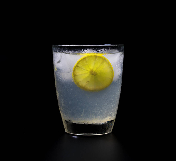 lemonade with ice in crystal glass on black background - Foto, imagen