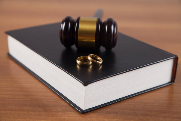 Tahta yargıç tokmak, kitap ve altın yüzükler, boşanma kavramı.. - Fotoğraf, Görsel