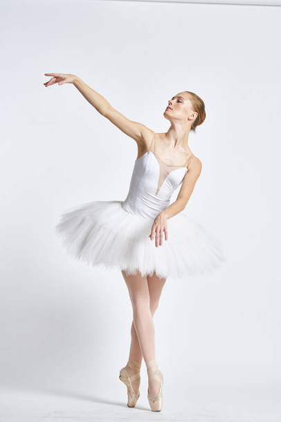 жінка-балерина в підручнику на світлому фоні позує. Високоякісна фотографія
 - Фото, зображення