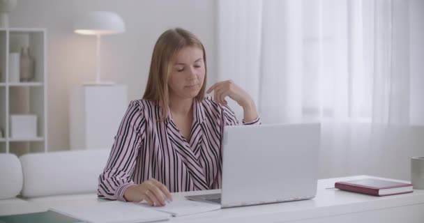 žena mluví on-line video chat a pocit bolesti hlavy, dotýkání spánků a šklebení, migréna v pracovní době - Záběry, video