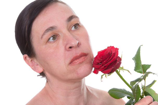Aikuisen naisen lähikuva ruusun kanssa. Merkkejä ihon vanhenemisesta 40 vuoden jälkeen - Valokuva, kuva