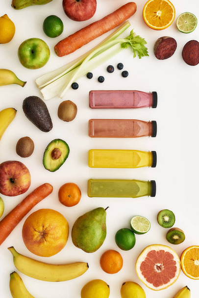 Top view composition of various colorful vegetables and fruits with bottles of healthy detox juices and smoothies isolated over white background - Foto, Imagem