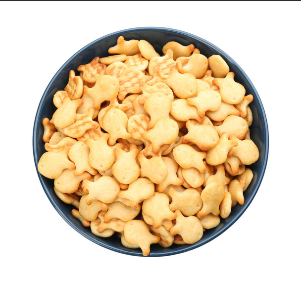 Delicious goldfish crackers in bowl isolated on white, top view - Photo, image