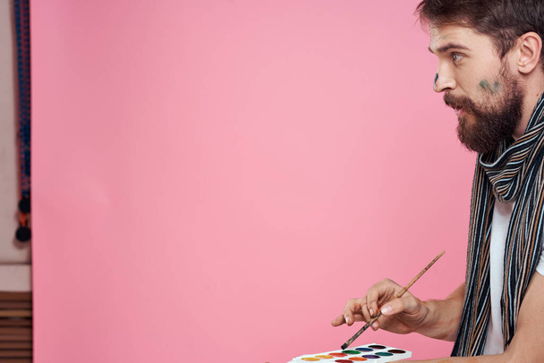 Artista masculino pincel pinturas arte hobby estilo de vida rosa fondo - Foto, imagen