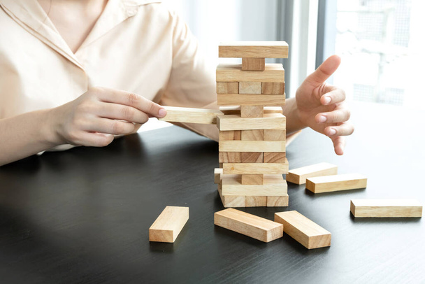 Handen van zakenvrouwen die houten blokkenspel spelen. Concept Risico van management en strategieplannen voor groei en succes van bedrijven. - Foto, afbeelding