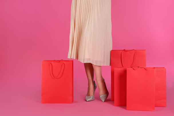 Woman with shopping bags on pink background, closeup. Black Friday Sale - Foto, Imagem